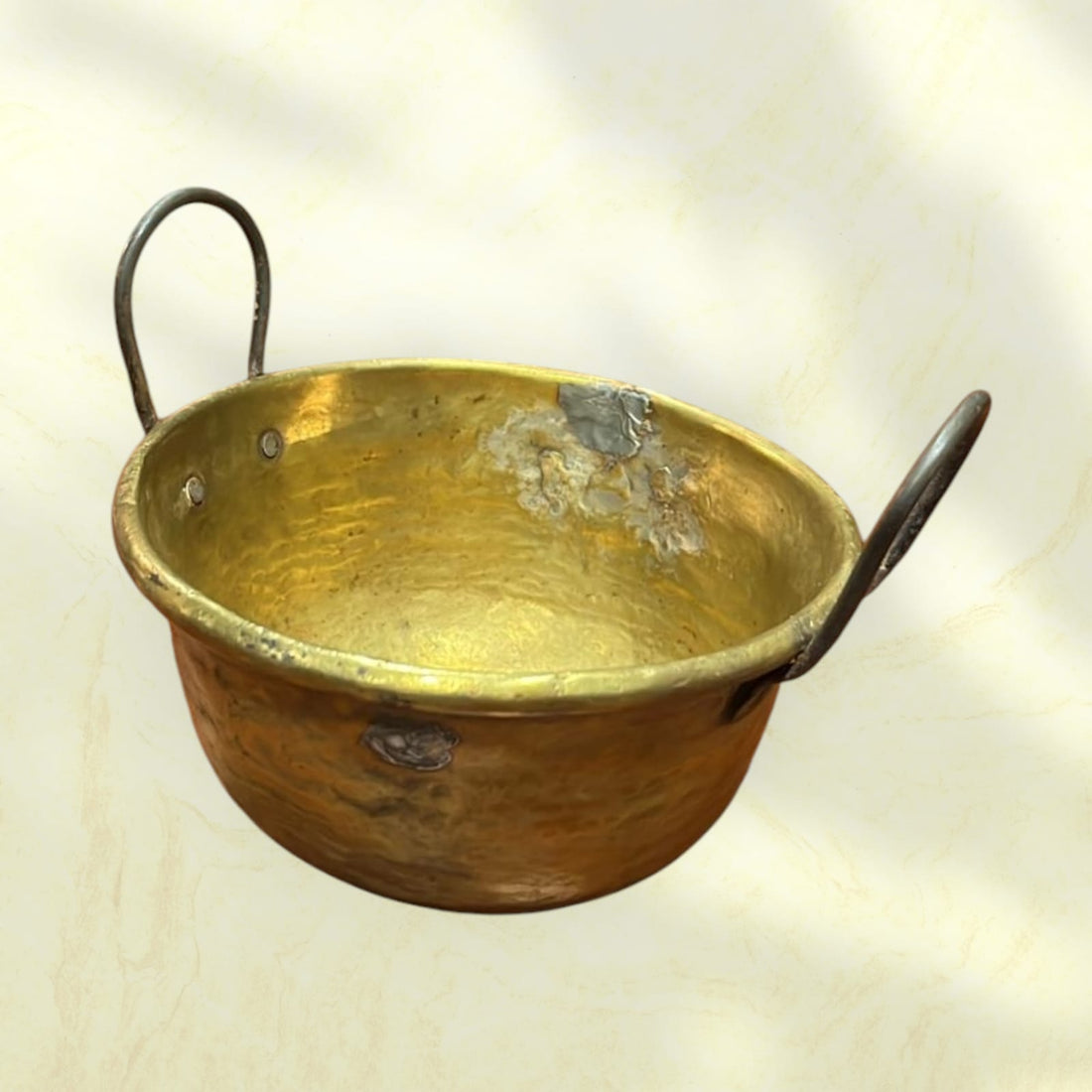 Caldero antiguo de metal con asas de hierro, pieza rústica ideal para decoración vintage en interiores o exteriores.