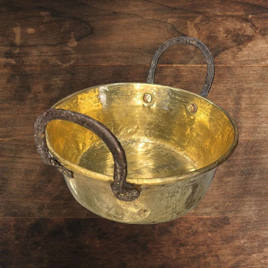 
El caldero de metal antiguo muestra un diseño clásico de líneas sencillas y funcionales, con cuerpo redondeado y base estable, características propias de los recipientes tradicional