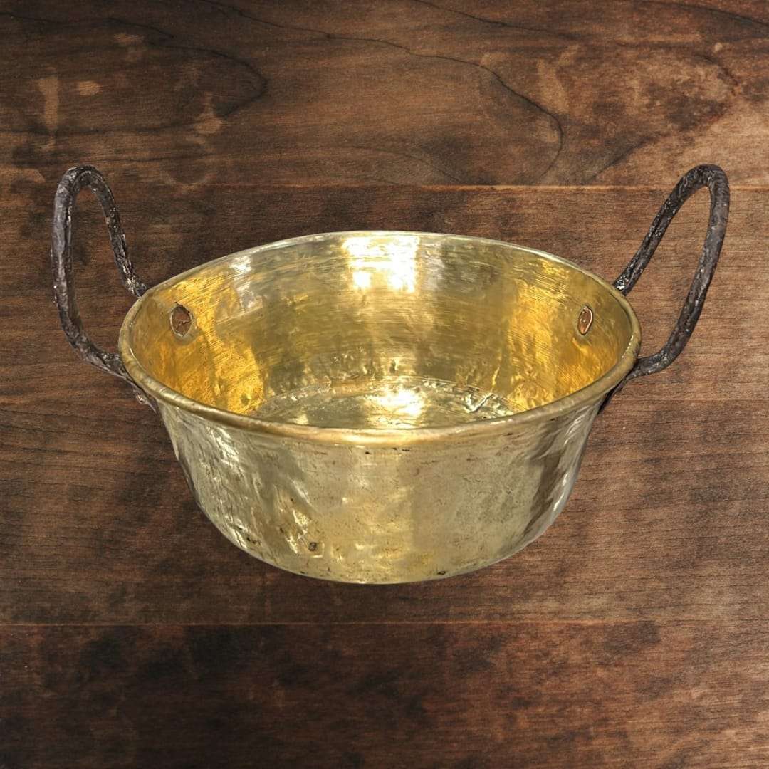 
El caldero de metal antiguo muestra un diseño clásico de líneas sencillas y funcionales, con cuerpo redondeado y base estable, características propias de los recipientes tradicional