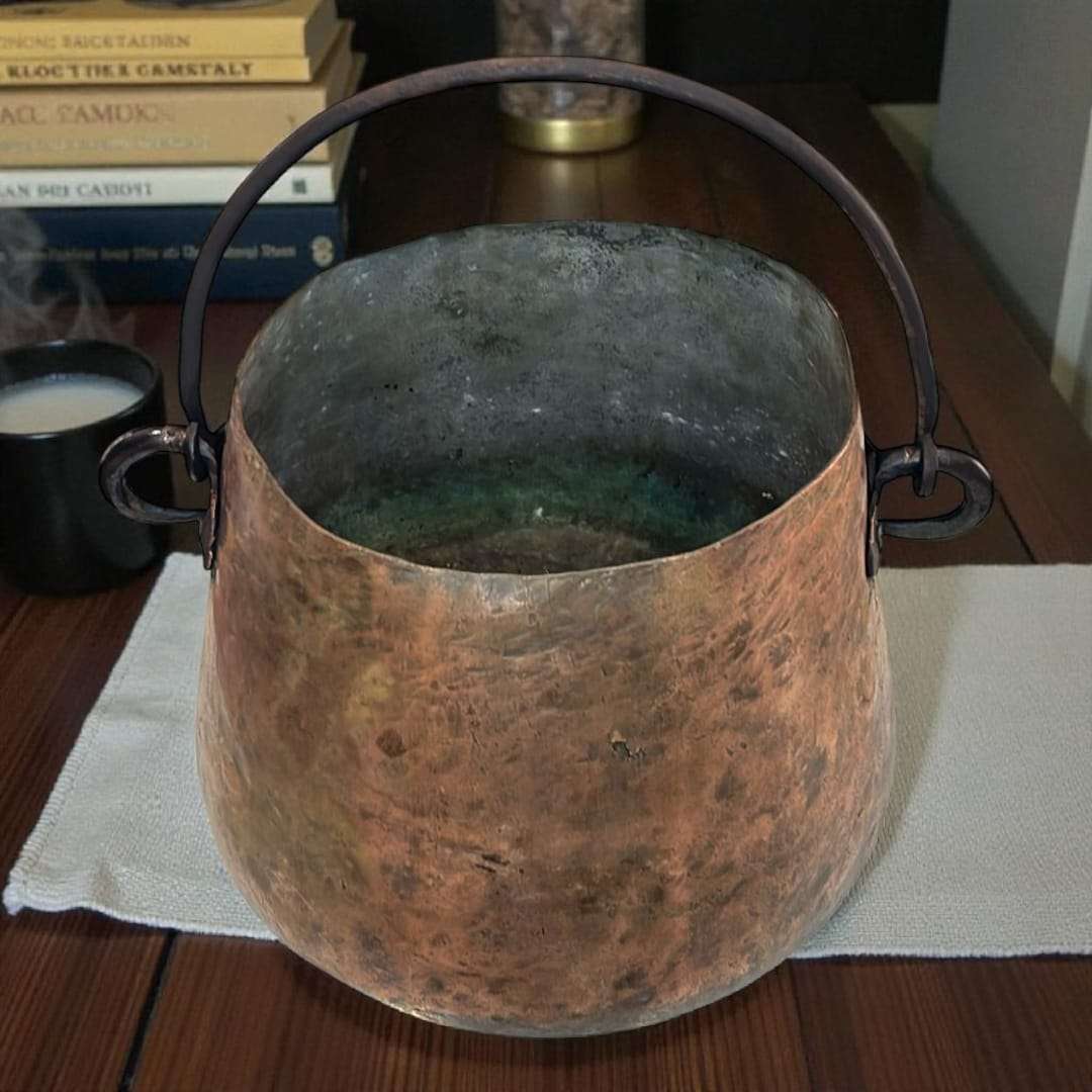 Caldero antiguo de cobre usado como decoración rústica.