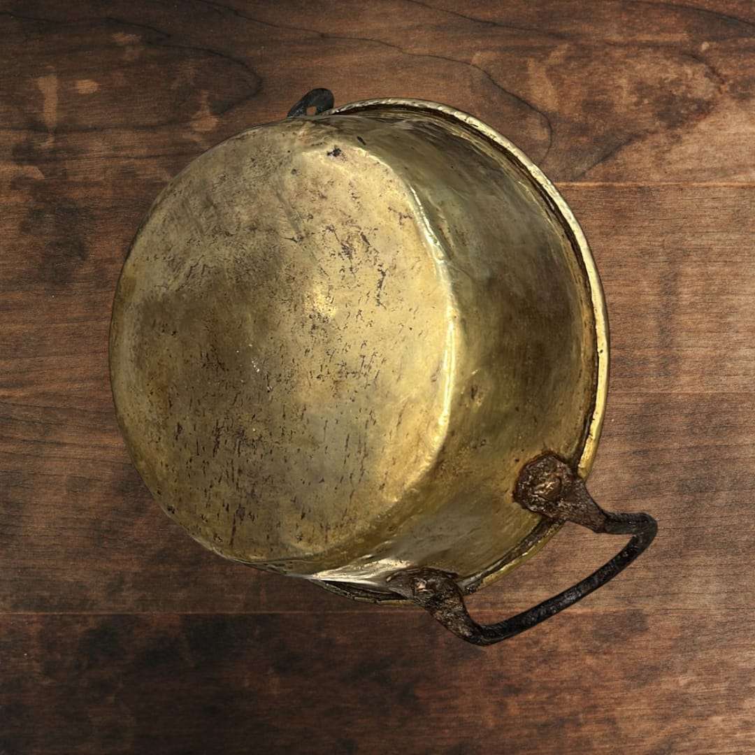 
El caldero de metal antiguo muestra un diseño clásico de líneas sencillas y funcionales, con cuerpo redondeado y base estable, características propias de los recipientes tradicional