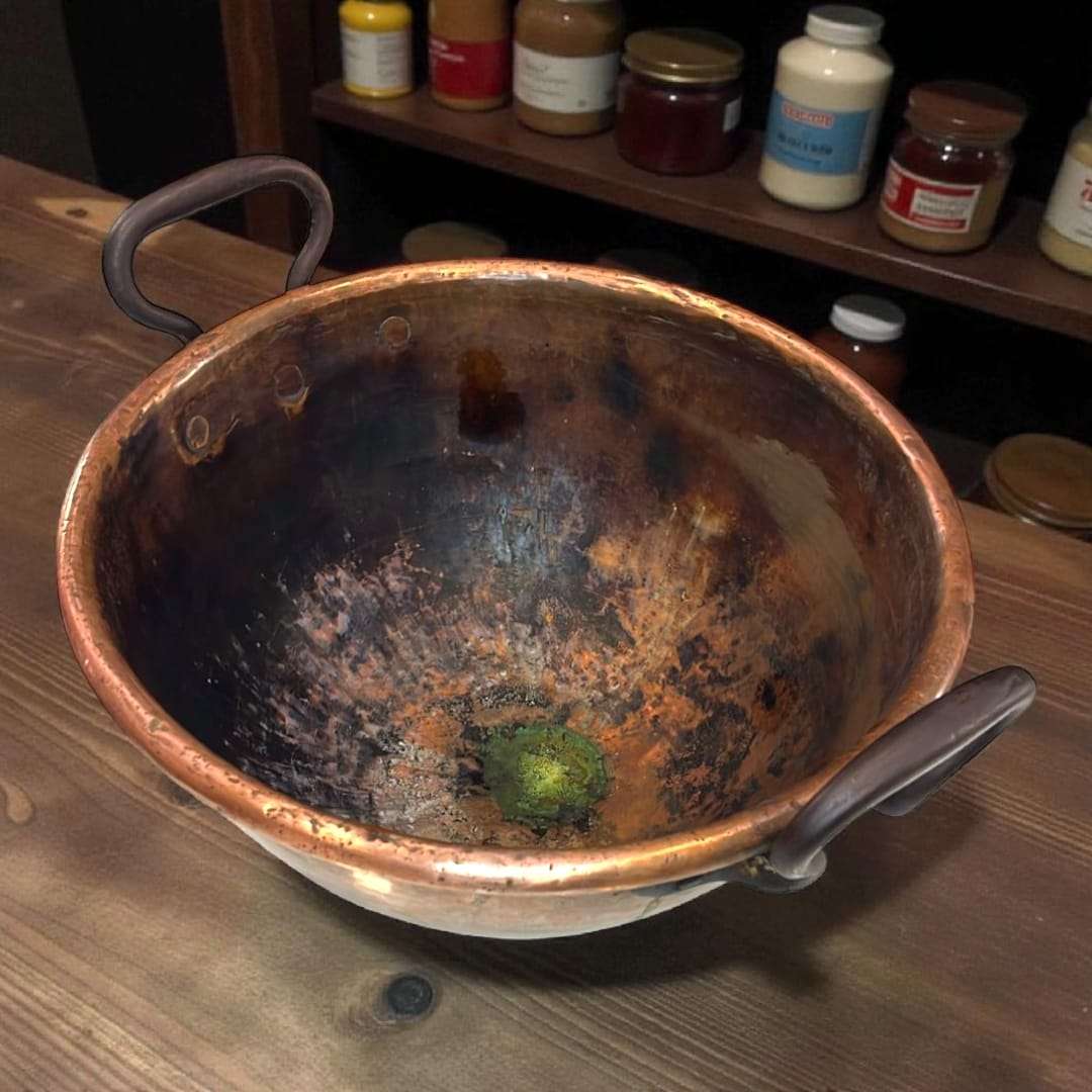 Caldero antiguo de cobre usado como decoración rústica.