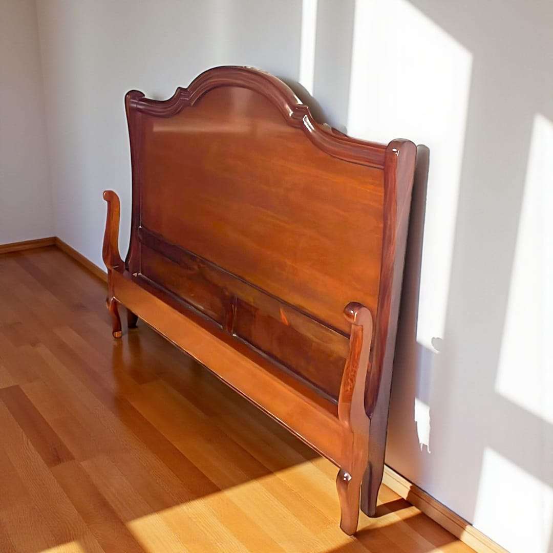 Cama de matrimonio de caoba con cabecero alto clásico.