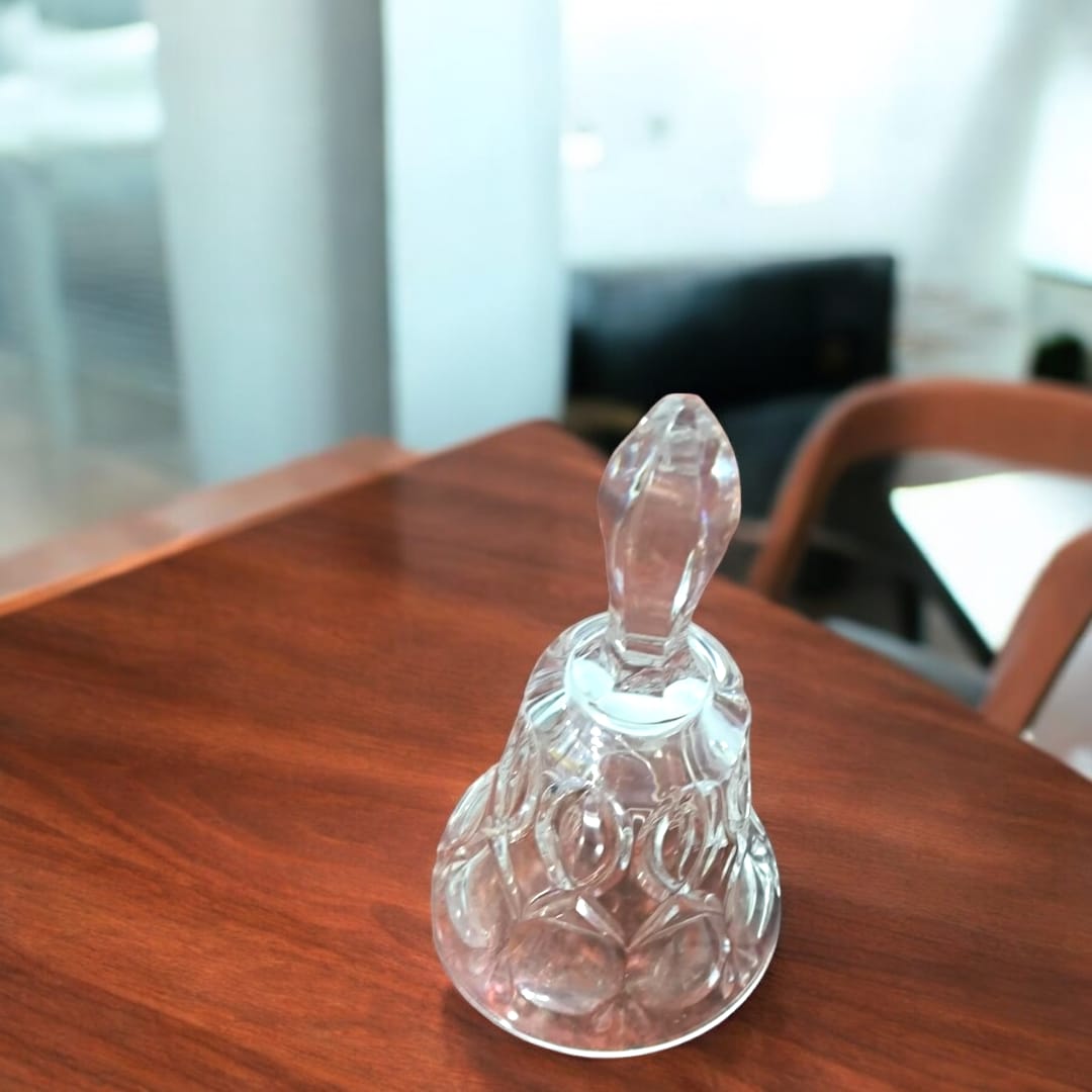 Campana de cristal tallado con diseño clásico sobre mesa de madera, ideal para decoración elegante en interiores modernos.