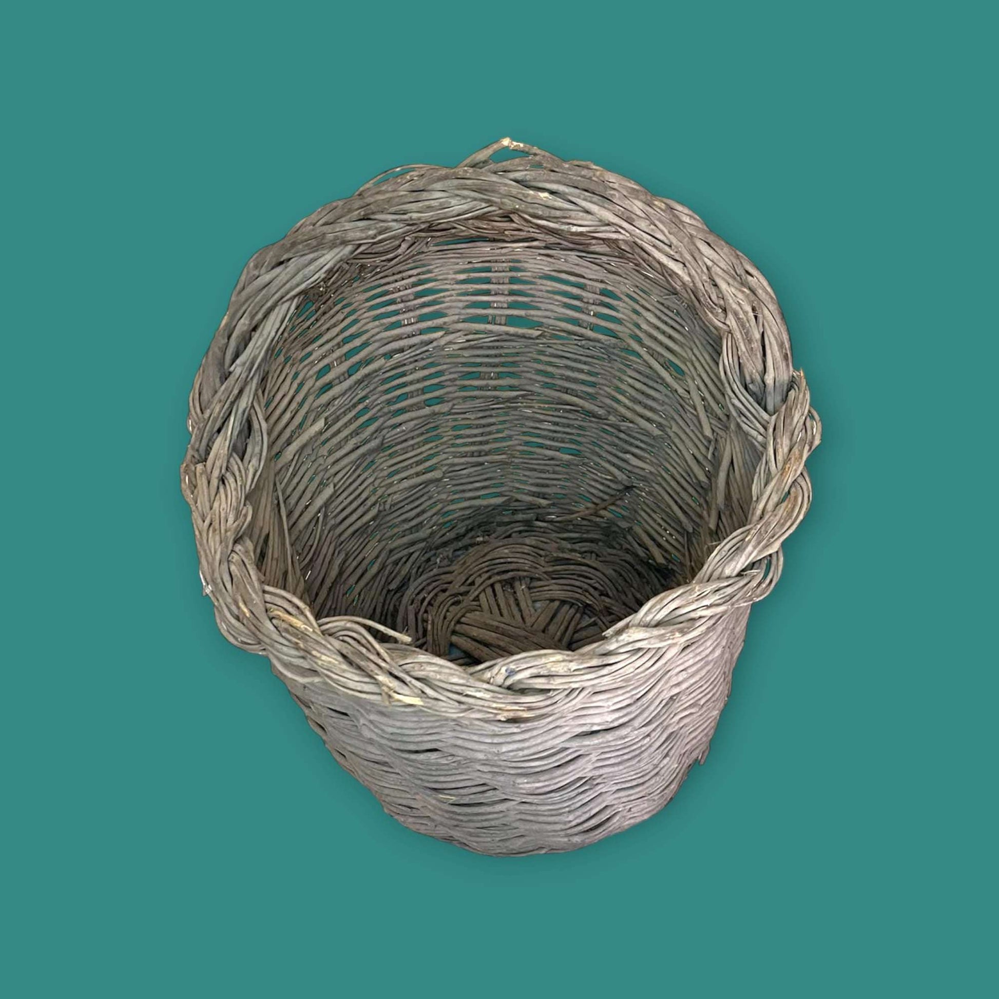 Canasta de mimbre hecha con baritas de olivo vista superior.