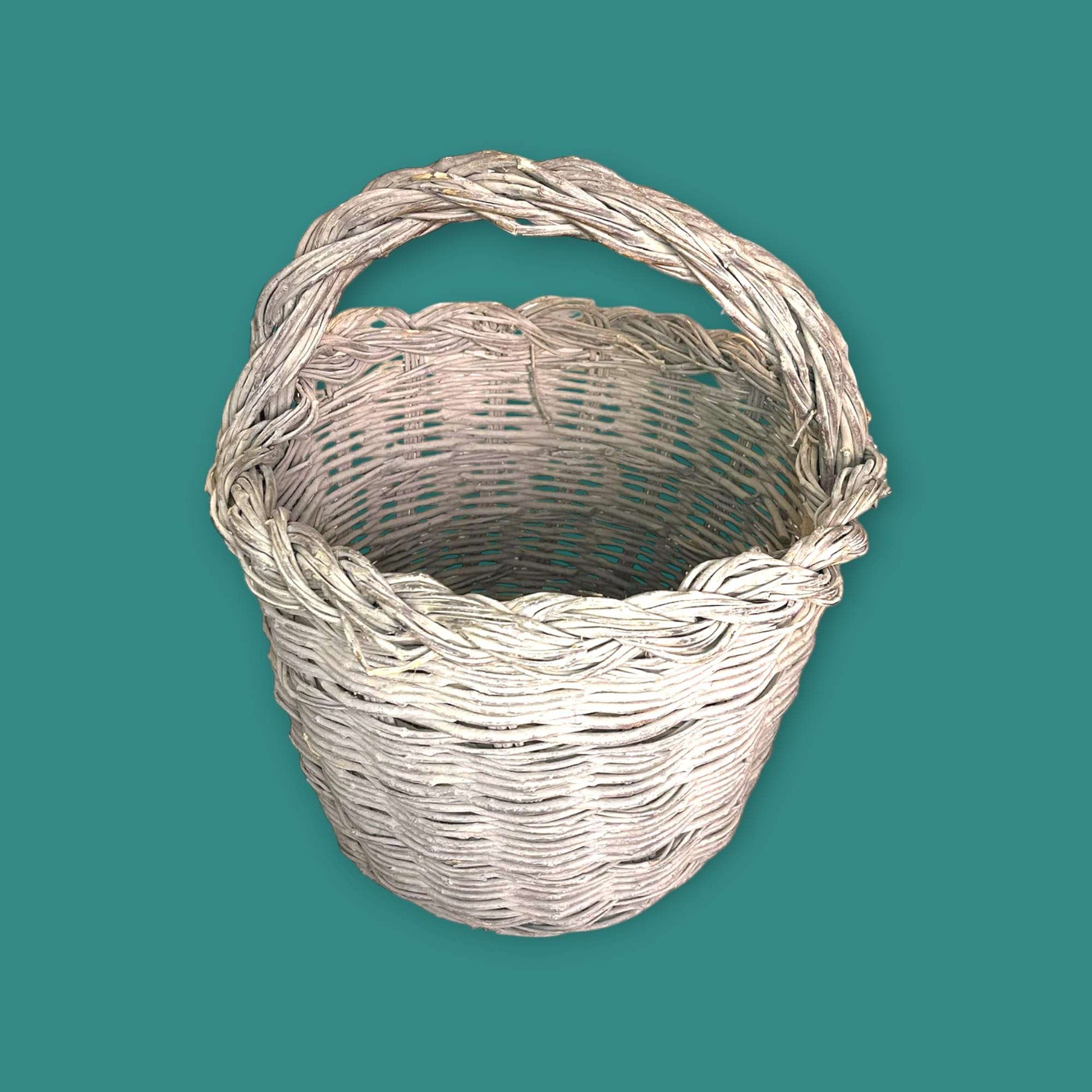 Canasta de mimbre hecha con baritas de olivo vista superior.