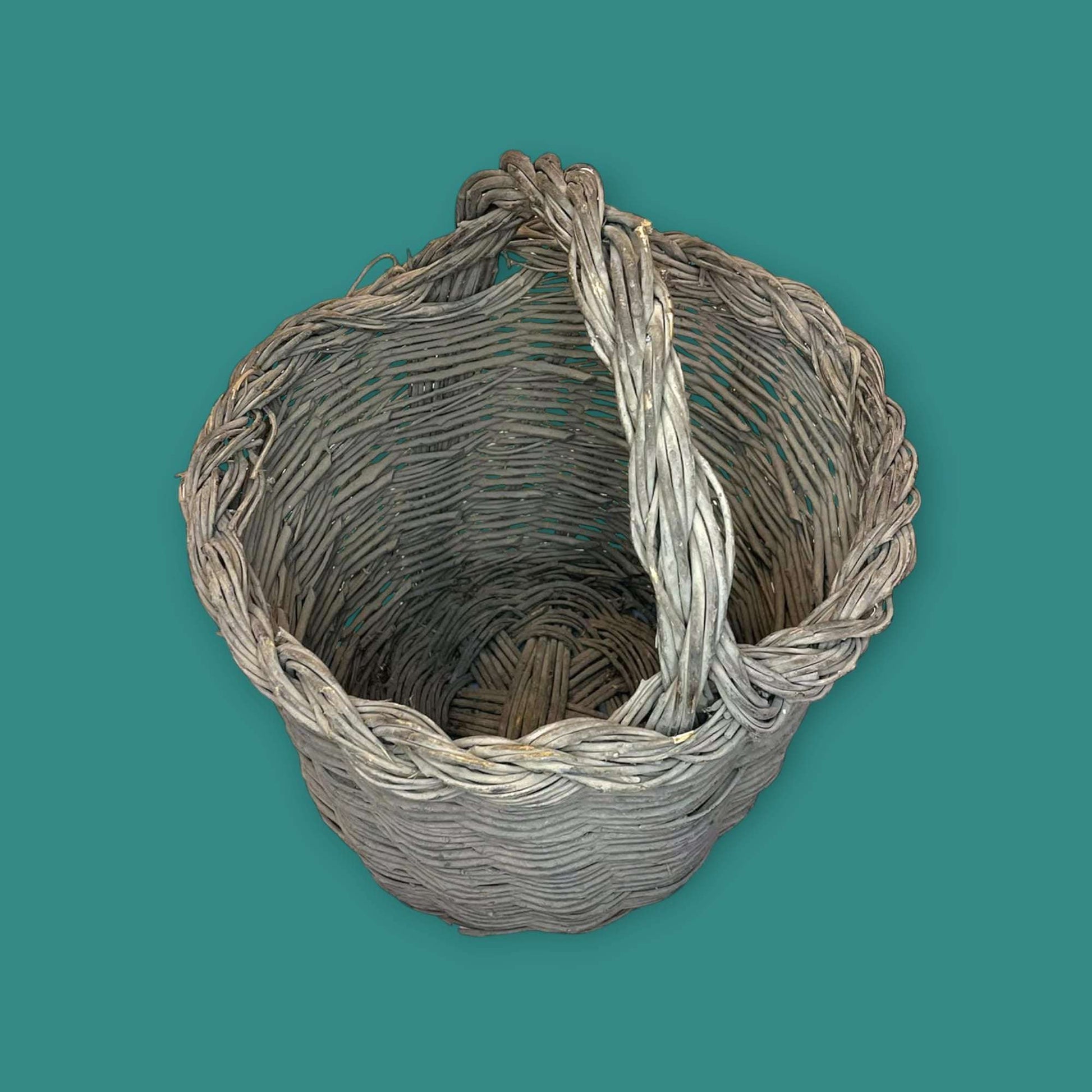 Canasta de mimbre hecha con baritas de olivo vista superior.