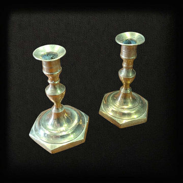 Pareja de candeleros de bronce pequeños sobre fondo negro