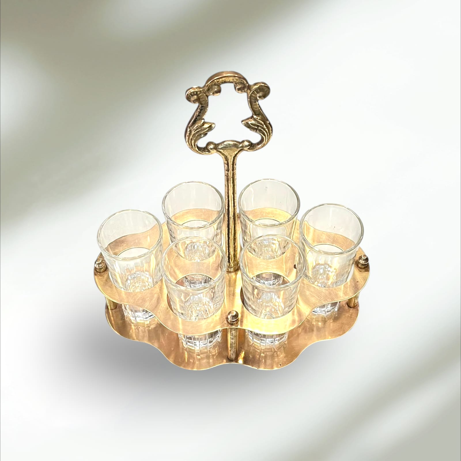 Cañero de metal dorado con diseño vintage y seis vasos de cristal transparente, ideal para decoración de hogar o bar con estilo retro.