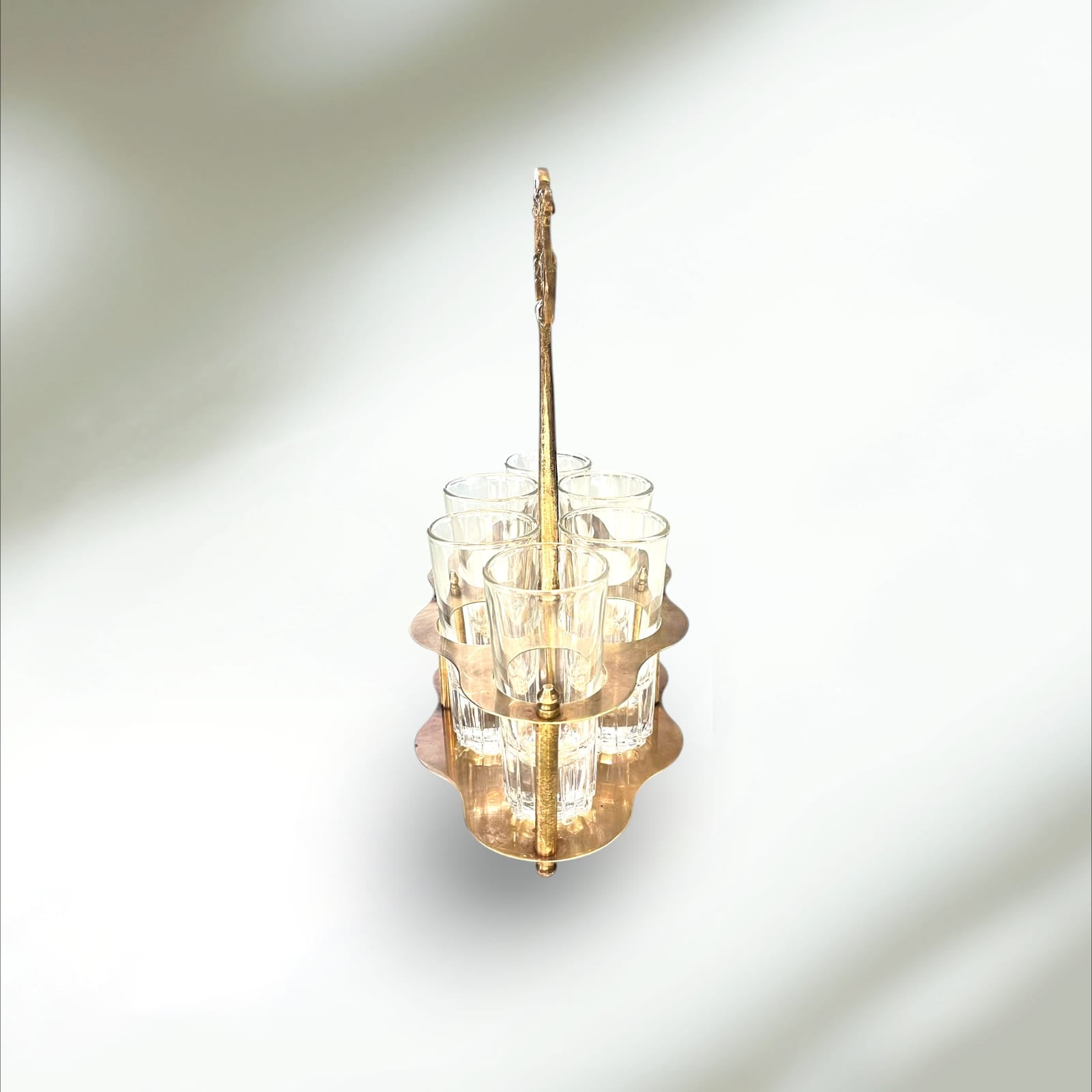 Cañero de metal dorado con seis vasos de cristal vintage, ideal para decoración de hogar o bar con estilo retro y elegante.