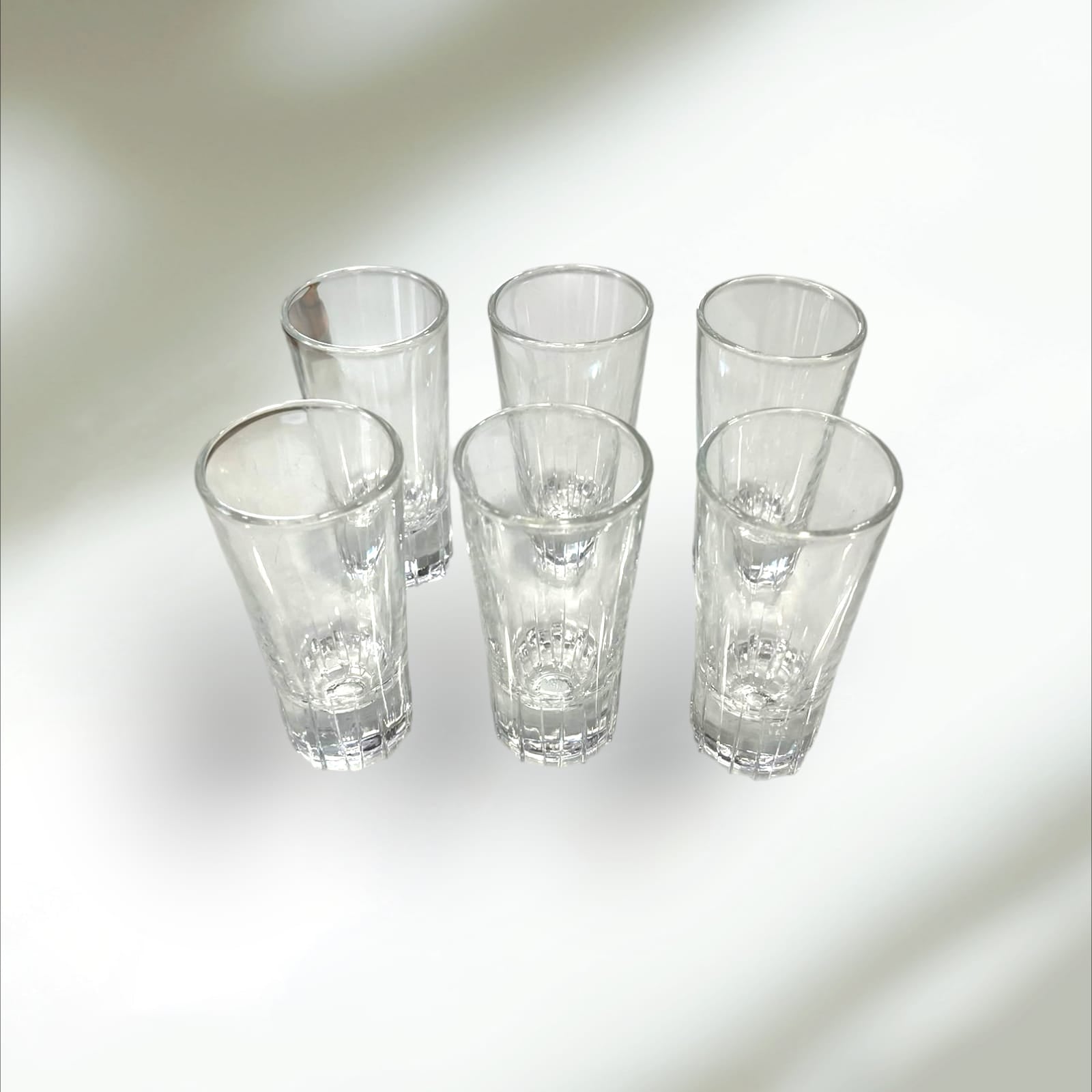 Seis vasos de cristal vintage transparentes, parte del cañero de metal dorado, ideales para decoración de hogar o bar con estilo retro.