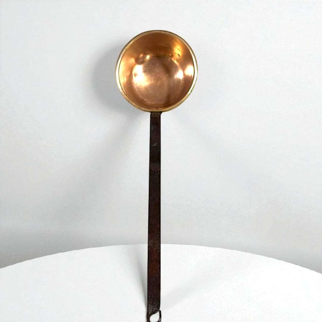 Cazo antiguo de metal con mango de hierro en vista lateral