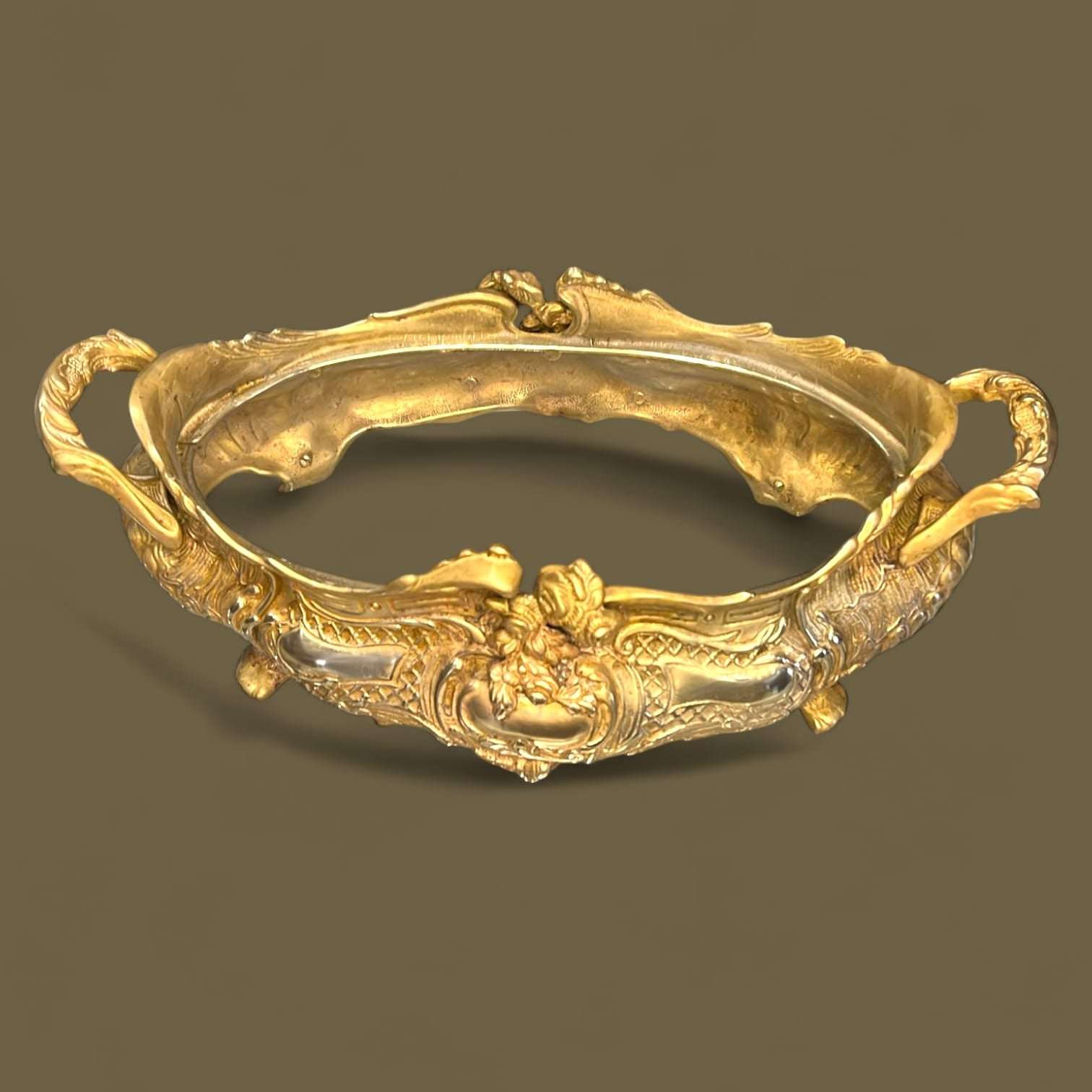 El acabado en bronce dorado, con una pátina natural conseguida por el paso del tiempo, realza los relieves y aporta profundidad visual.