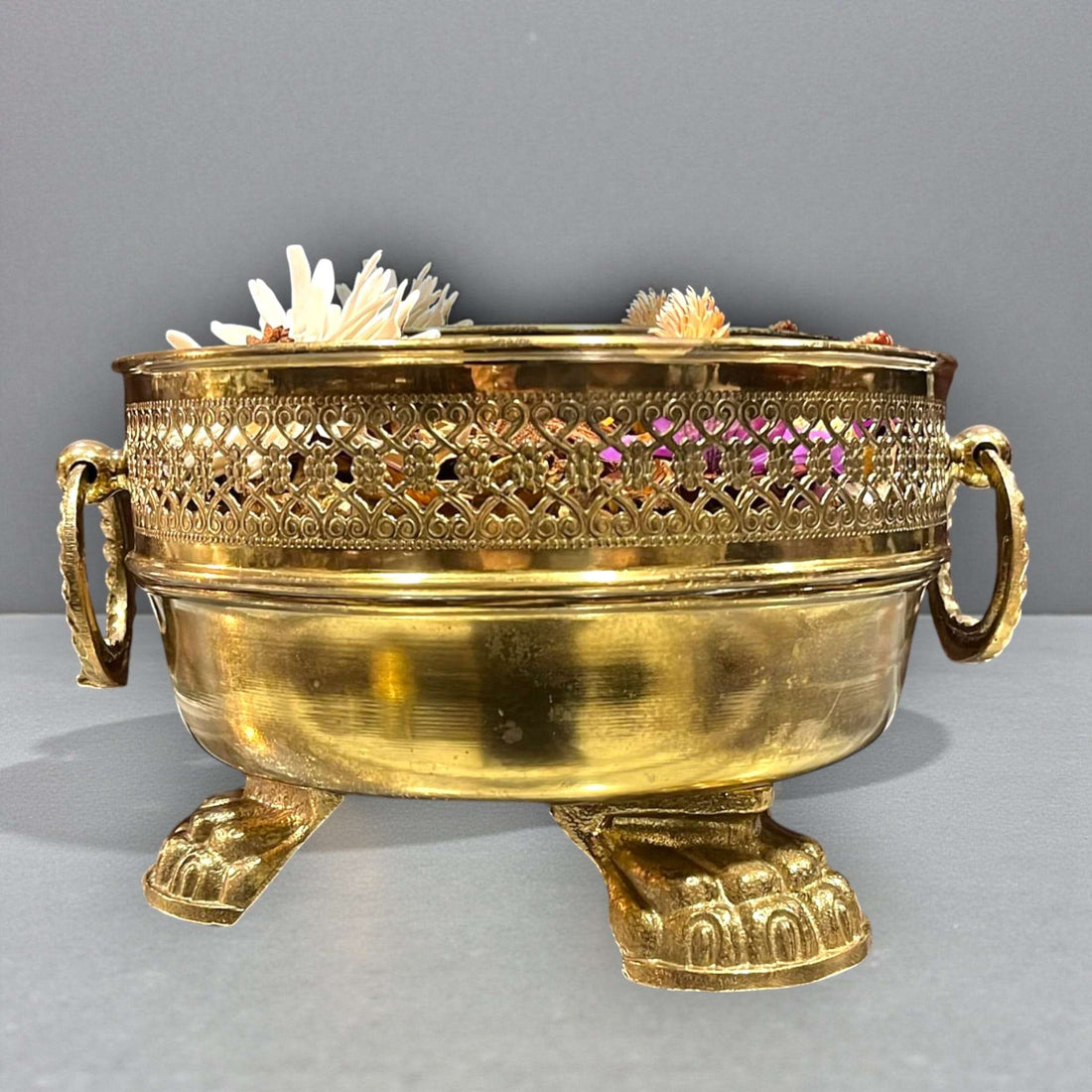 Este Centro floral de metal dorado es una pieza decorativa única, pensada para quienes valoran los objetos con carácter, historia y presencia.