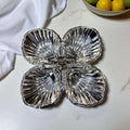 Entremecero de metal plateado con cuatro divisiones simétricas y asa central, ideal para decoración de mesa en eventos o uso doméstico exclusivo.