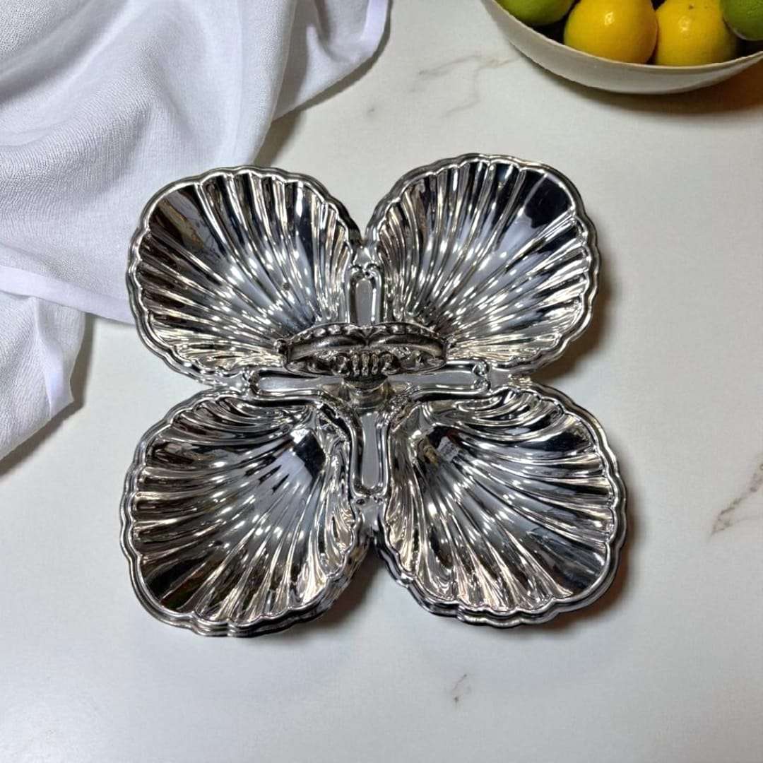 Entremecero de metal plateado con cuatro divisiones simétricas y asa central, ideal para decoración de mesa en eventos o uso doméstico exclusivo.