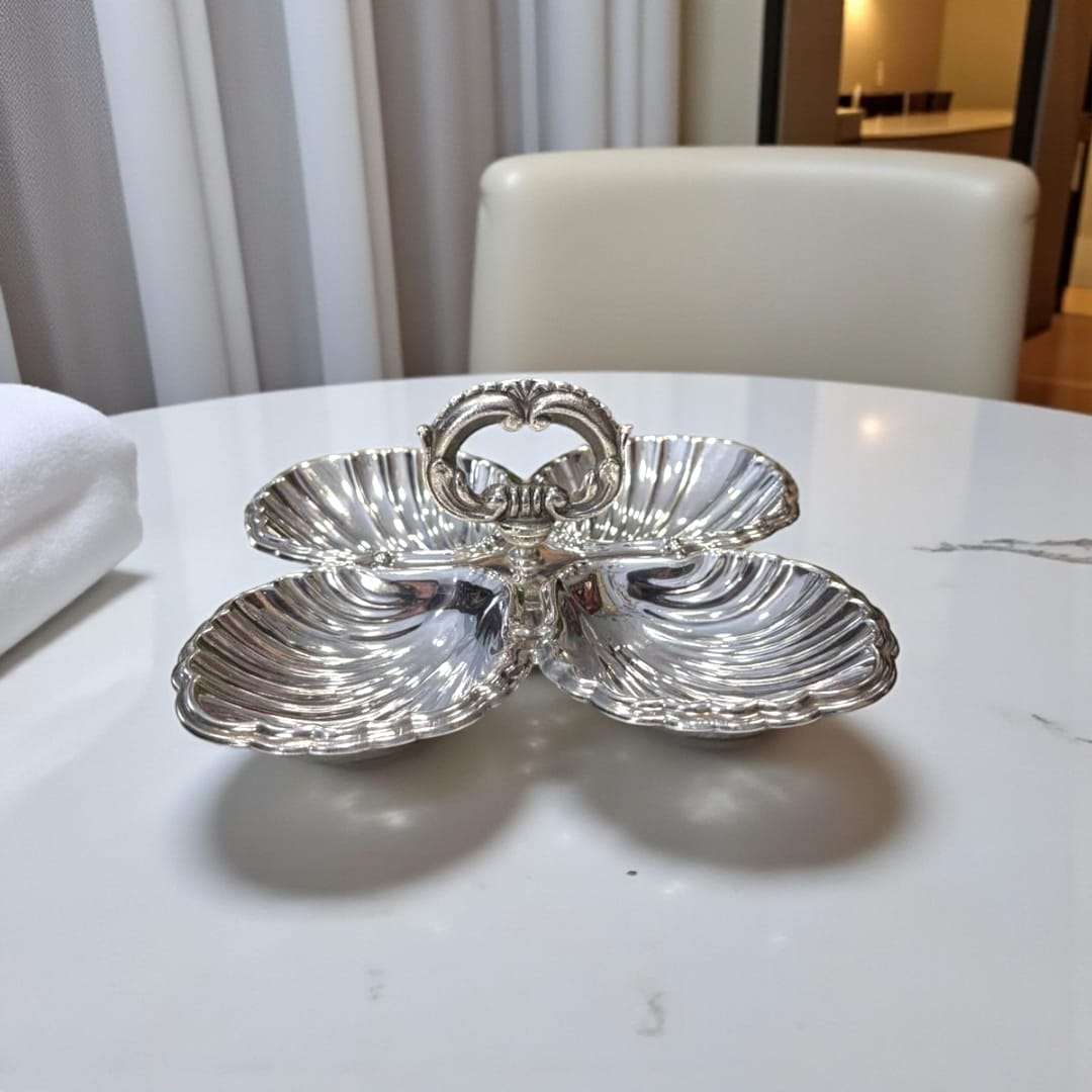 Entremecero de metal plateado con asa central antiguo sobre mesa blanca, ideal para servir entremeses con elegancia en decoración de hogar.