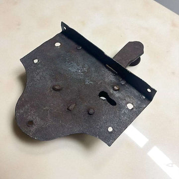 Cerradura antigua de hierro con pestillo visible.