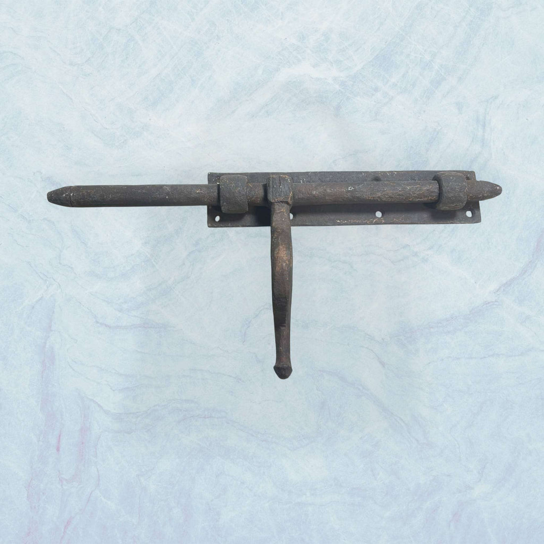 Cerrojo antiguo de forja artesanal con manilla curvada.