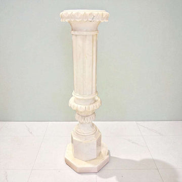Columna o pedestal de alabastro iluminado con luz cálida.