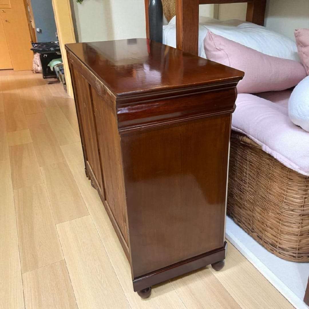 Cómoda de caoba con tapa de cristal vista lateral.