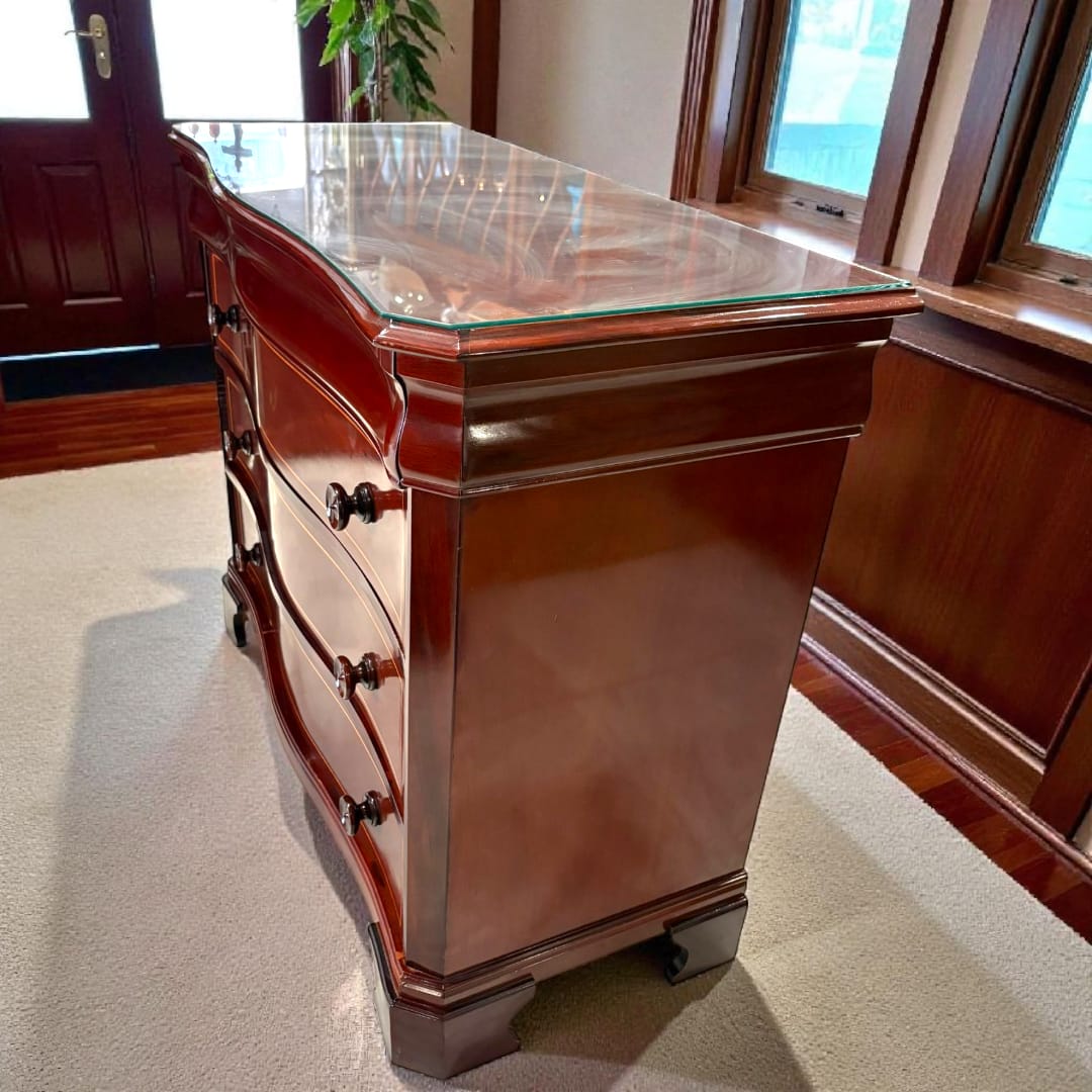 Cómoda de caoba con tapa de cristal vista frontal.