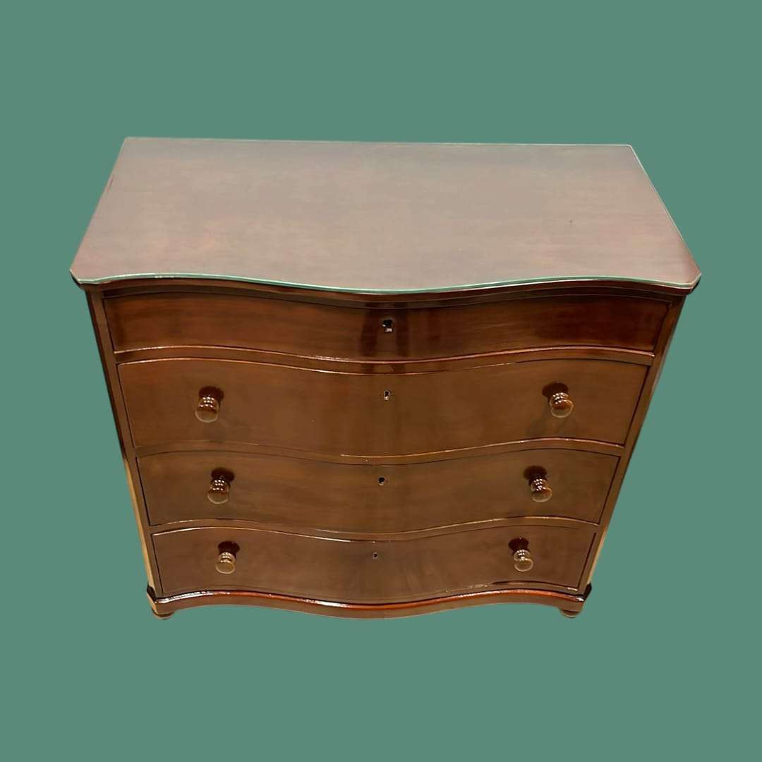 Cómoda de caoba con tapa de cristal, tres cajones curvos y secreté, ideal para decoración elegante en el hogar. Mueble funcional y refinado.