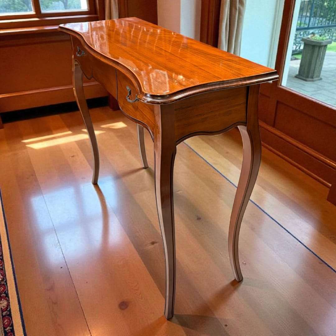 Consola de caoba con cajón, diseño clásico con patas curvas y acabado brillante. Ideal para decoración vintage en recibidores o salones elegantes.