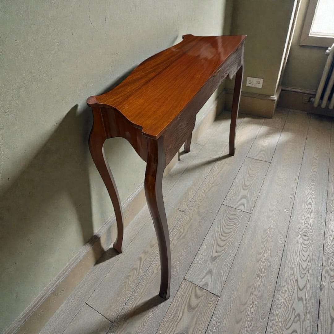 La Consola de caoba que presentamos es una pieza decorativa sofisticada, de líneas fluidas y un acabado de altísima calidad. 