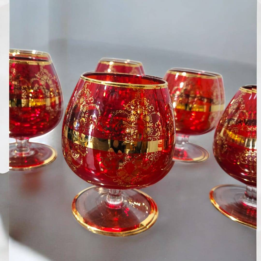 Juego de 6 copas de cristal Murano rojo con detalles dorados pintados a mano. Diseño elegante y exclusivo para realzar la decoración de tu mesa.