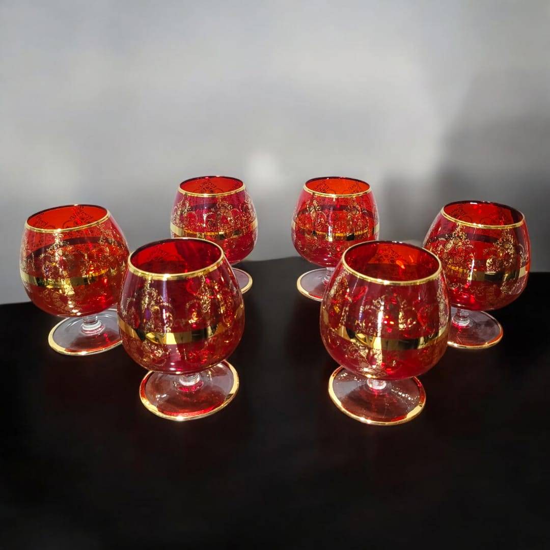 Juego de 6 copas de cristal Murano rojo con detalles dorados pintados a mano. Diseño elegante y exclusivo para realzar la decoración de tu mesa.