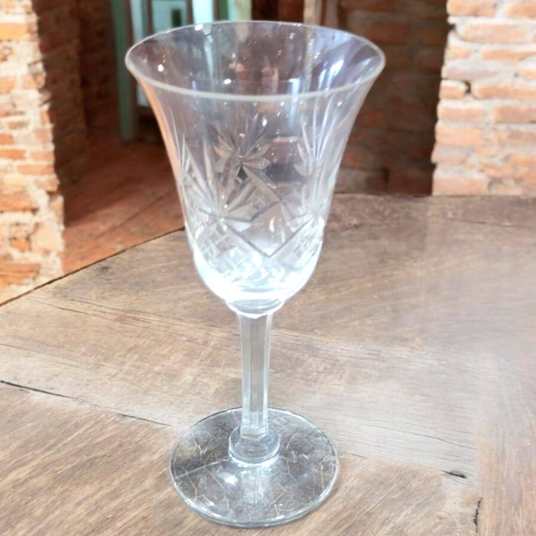 Set de 7 copas de cristal de Bohemia talladas a mano sobre mesa de madera. Decoración elegante para el hogar con estilo clásico.