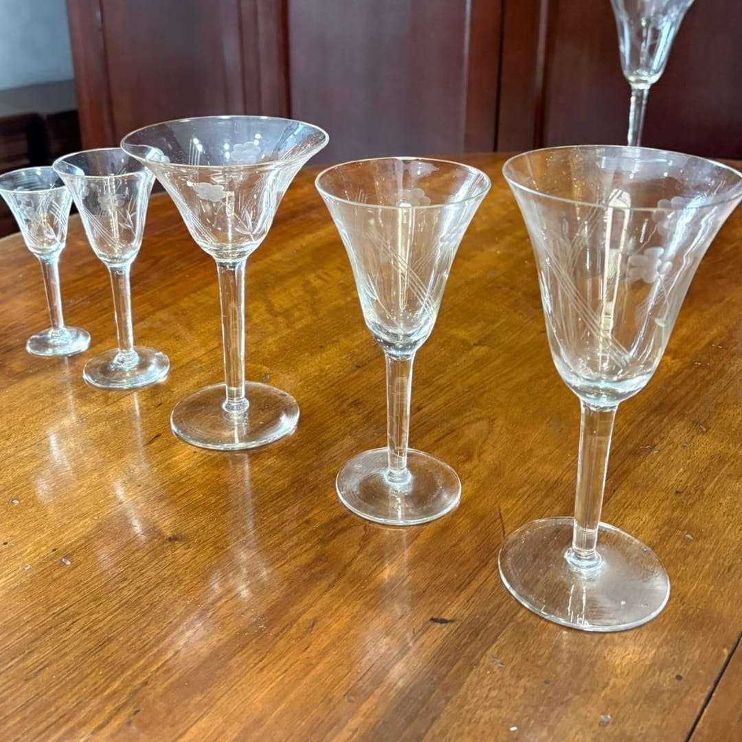 Detalle de copas talladas de cristal antiguo en diferentes tamaños, parte del conjunto de cristalería antigua para decoración elegante.