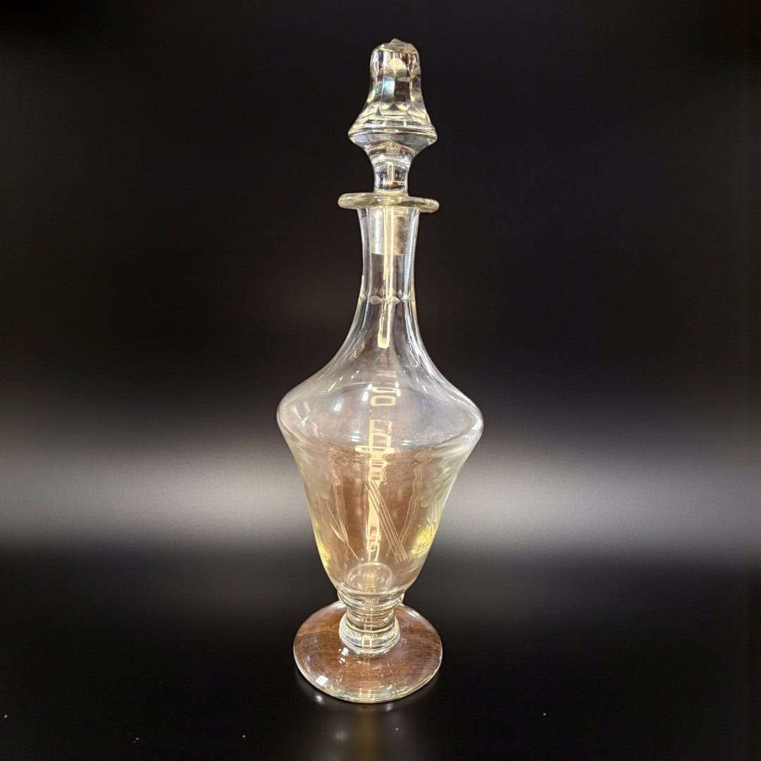 Licorera antigua de cristal tallado con tapa, pieza central del conjunto de cristalería antigua para decoración de interiores.
