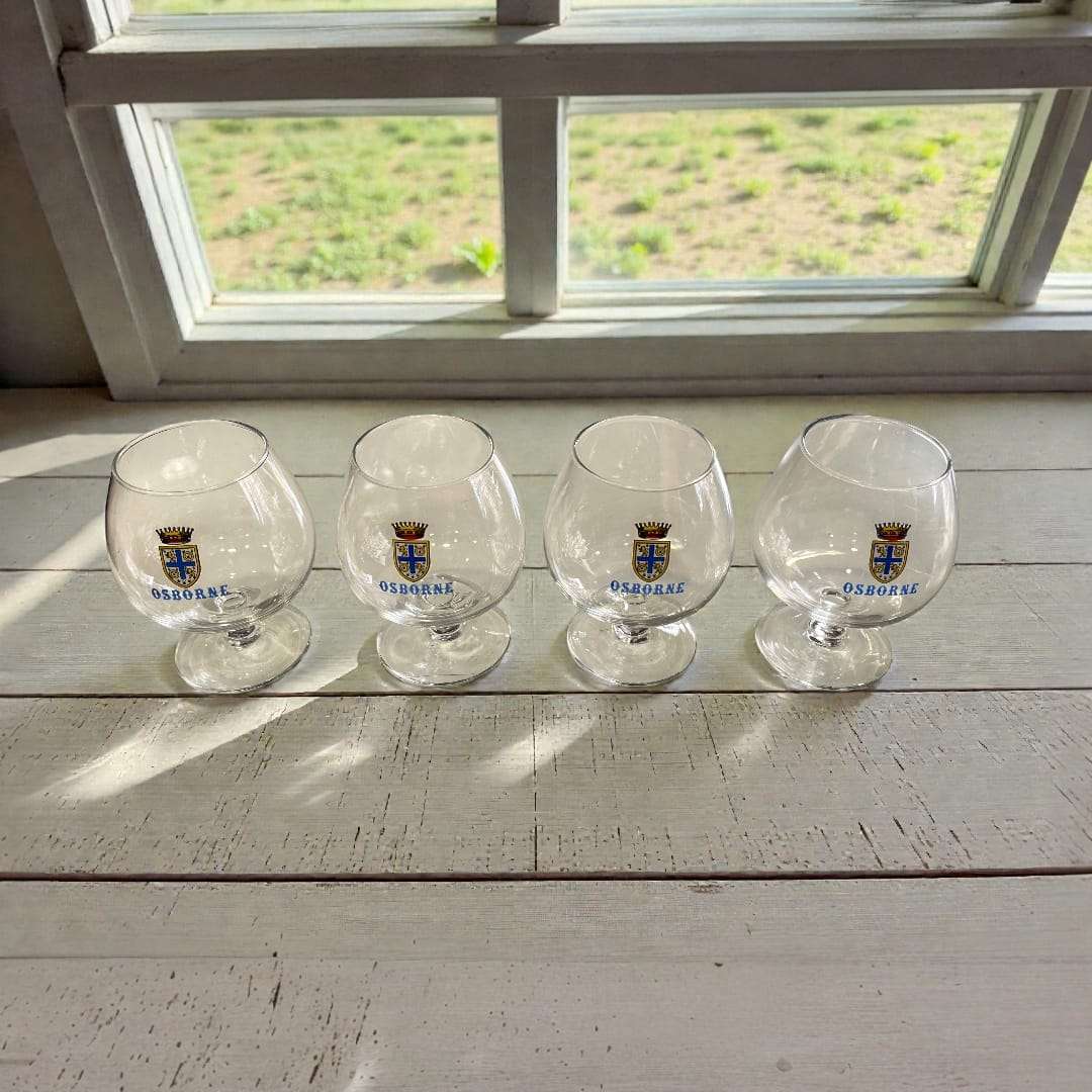 Cuatro copas antiguas de coñac Osborne años 70 con escudo dorado, colección de cristalería vintage para decoración de interiores.