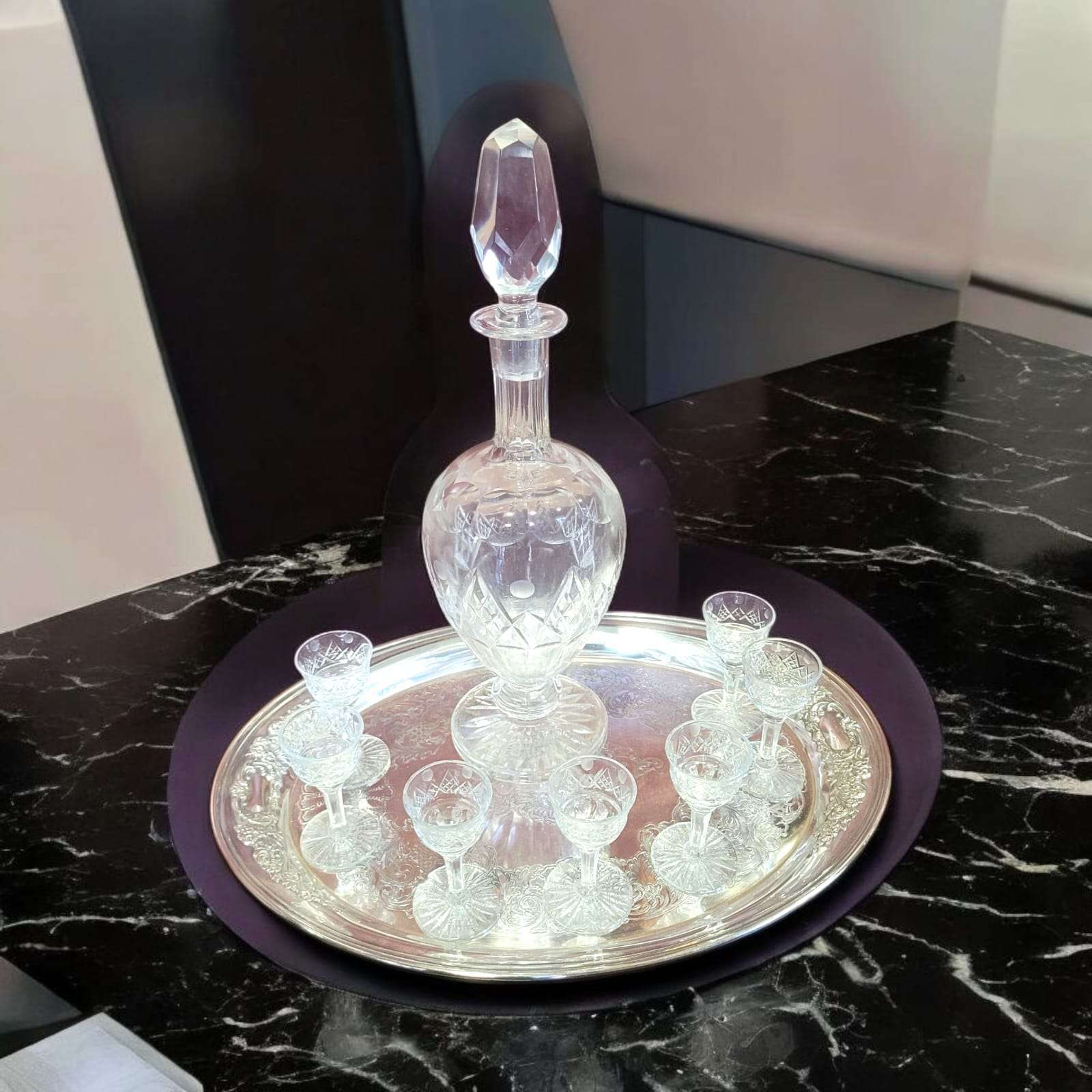 Juego de copas de licor de cristal tallado antiguo con licorera en bandeja de plata, conjunto decorativo de estilo clásico y refinado.