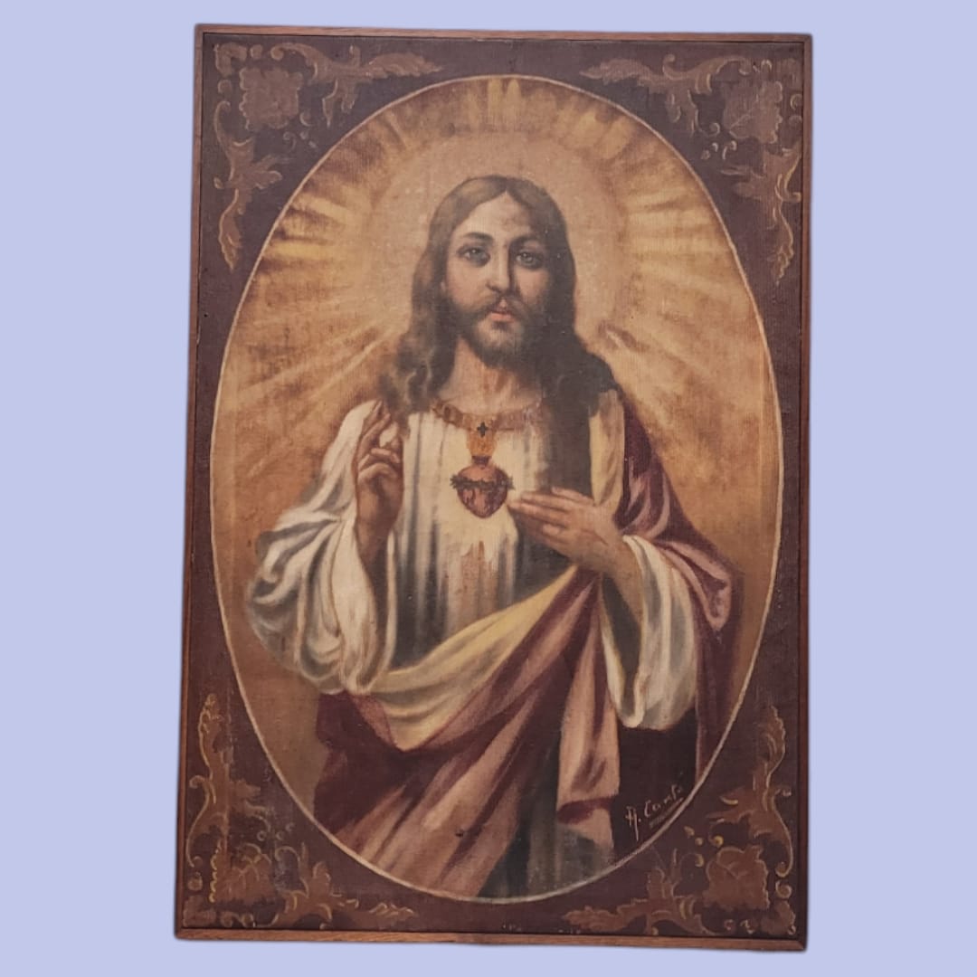 Pintura del Sagrado Corazón de Jesús en óleo sobre tela con detalles dorados y fondo ovalado, ideal para decoración religiosa.