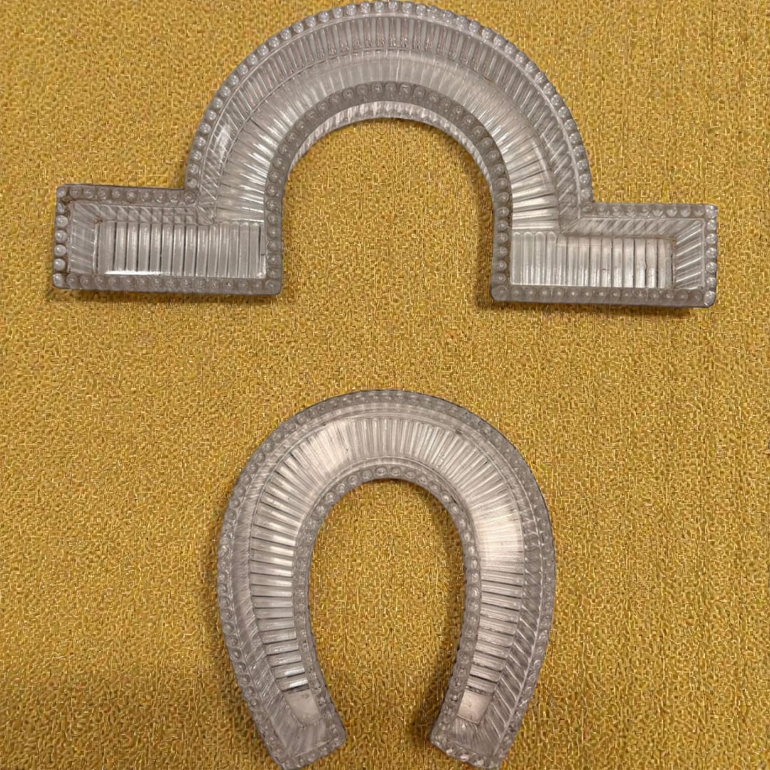 Set de caminos de mesa de cristal Art Decó con diseño modular en herradura y curva, borde perlado y relieve estriado sobre fondo amarillo.