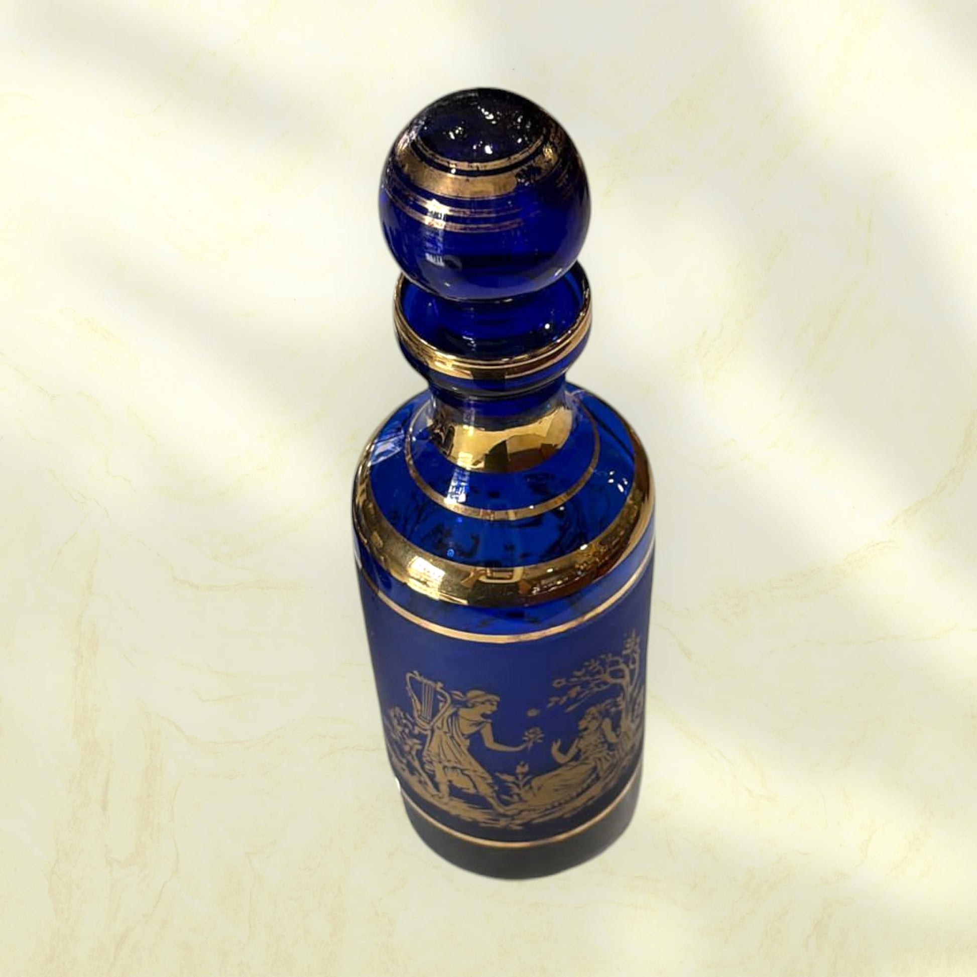 Detalle del vaso azul cobalto con motivos clásicos dorados.