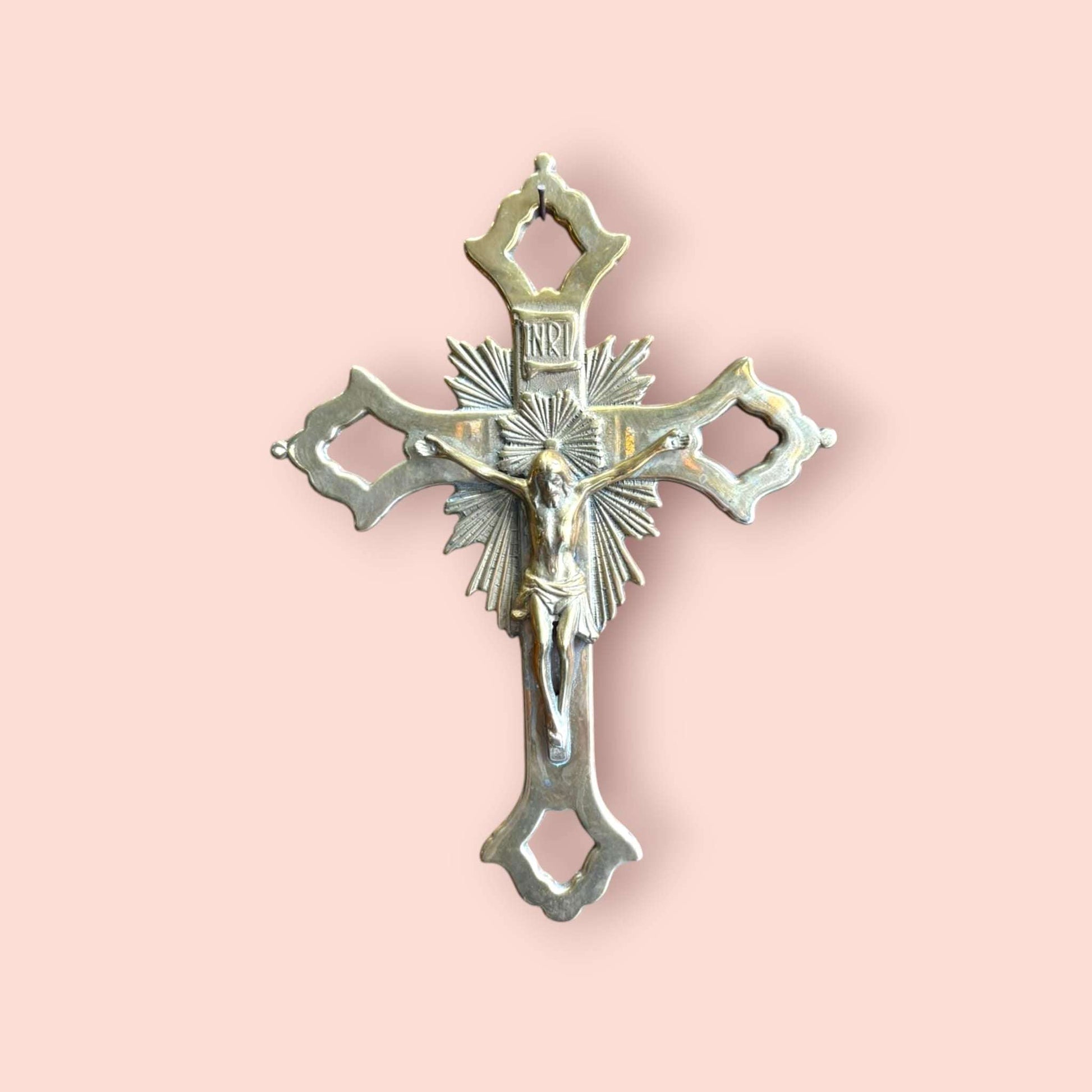 Crucifijo de metal dorado decorativo con Cristo tallado.