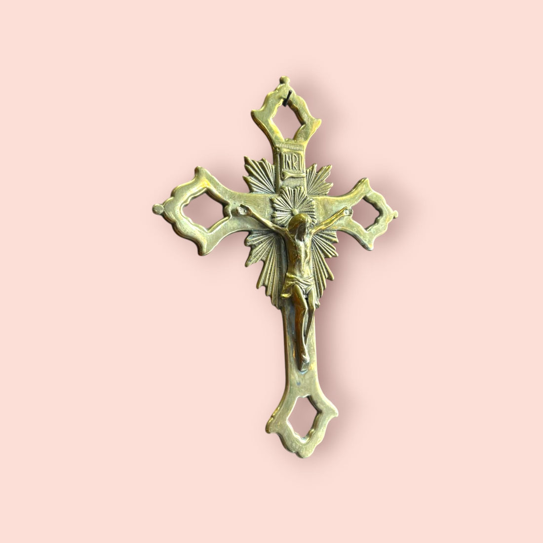 Crucifijo de metal dorado decorativo con Cristo tallado.