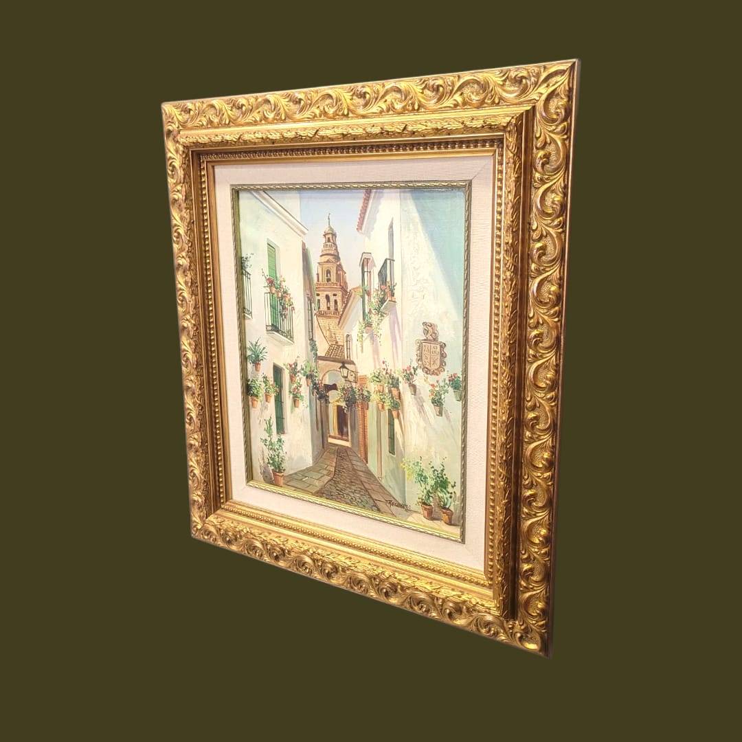 Cuadro original al óleo de Retamero mostrando calle andaluza con flores y torre, en marco dorado clásico, pieza única para decoración de interiores.
