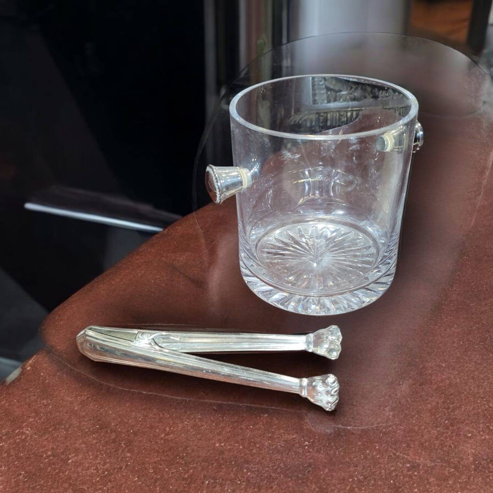 Elegante cubitera de cristal tallado con base estrellada y pinzas de alpaca, perfecta para bares o mesas de comedor sofisticadas.