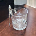 Cubitera de cristal tallado con diseño clásico y pinzas colgando del asa, ideal para decoración y uso funcional en el hogar.