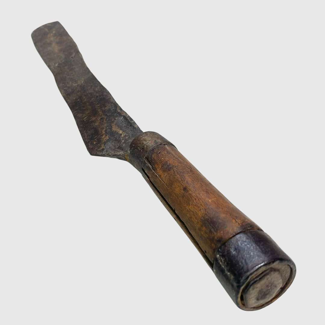 Cuchillo decorativo antiguo de cobre y madera rústica.