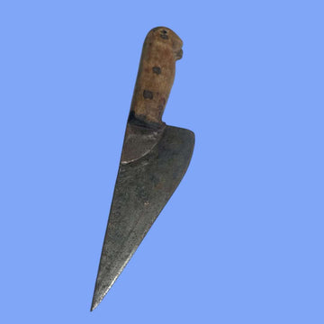 Cuchillo de carnicero antiguo visto en detalle, hoja de acero y mango de madera.