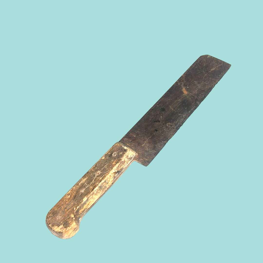 Cuchillo antiguo con mango de madera y hoja de hierro visto en diagonal.