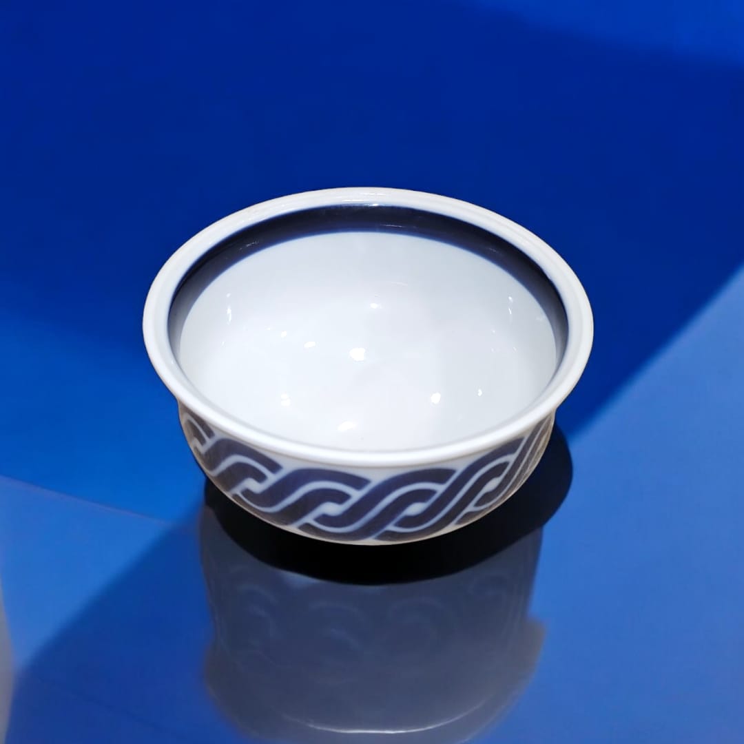 Cuenco de porcelana Sargadelos en azul y blanco con diseño gallego tradicional sobre fondo azul brillante.