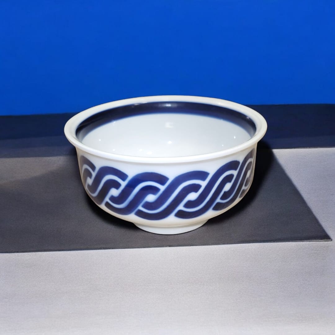 Cuenco de porcelana Sargadelos en azul y blanco con diseño gallego tradicional sobre fondo azul brillante.