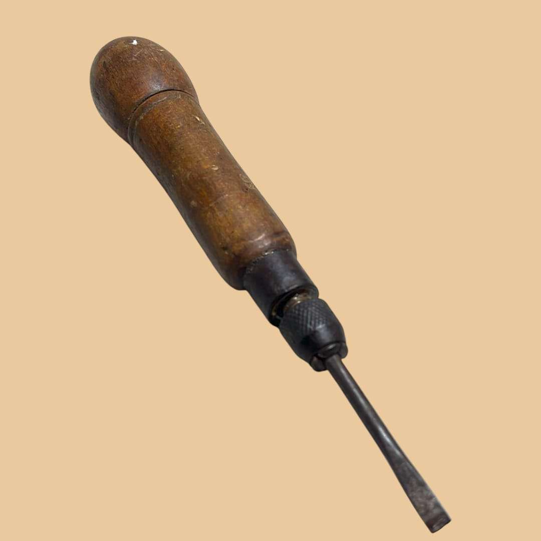 Destornillador desmontable antiguo con mango de madera y punta plana, herramienta única de colección para decoración vintage en hogar y jardín.
